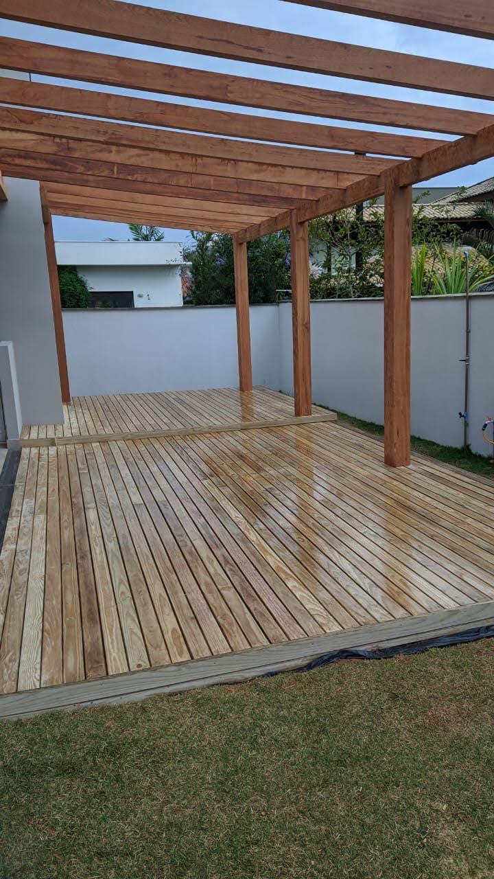 Estrutura de pergolado de madeira recém-instalada sobre deck elevado em quintal